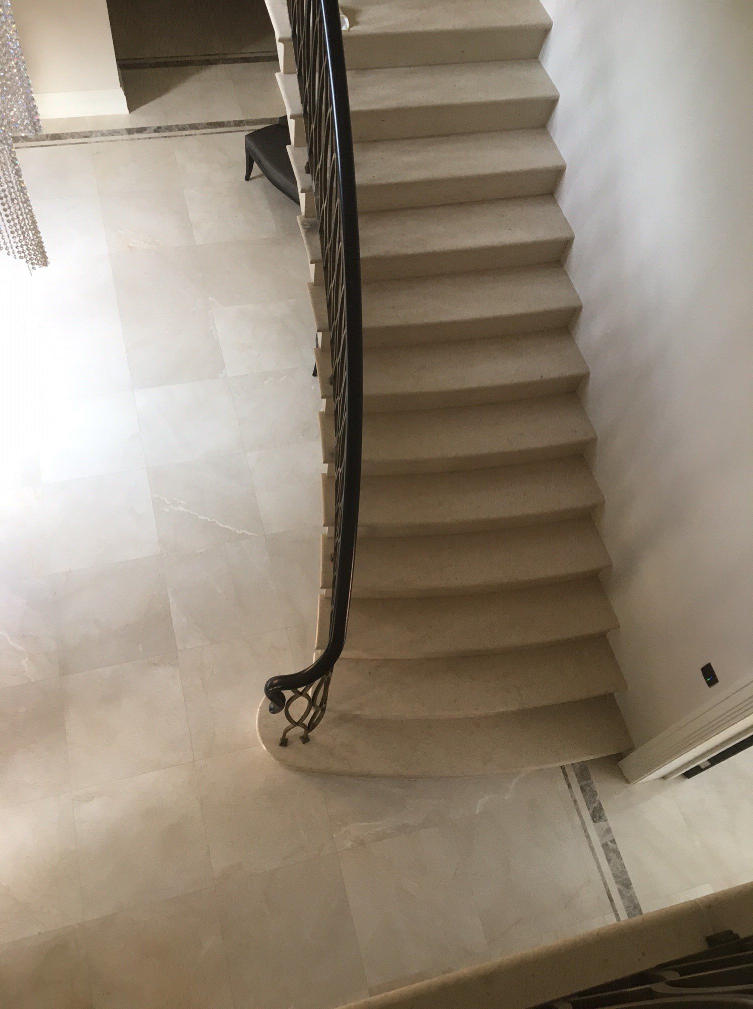 An aerial view of a staircase with a wrought iron railing.