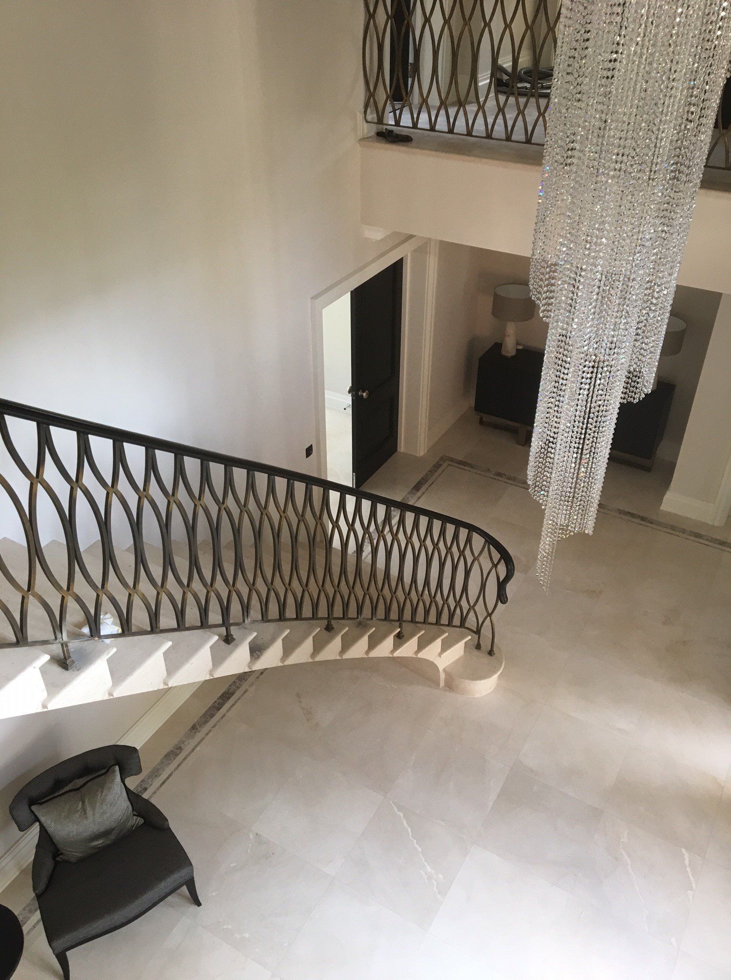 An aerial view of a staircase with a chandelier hanging from the ceiling.