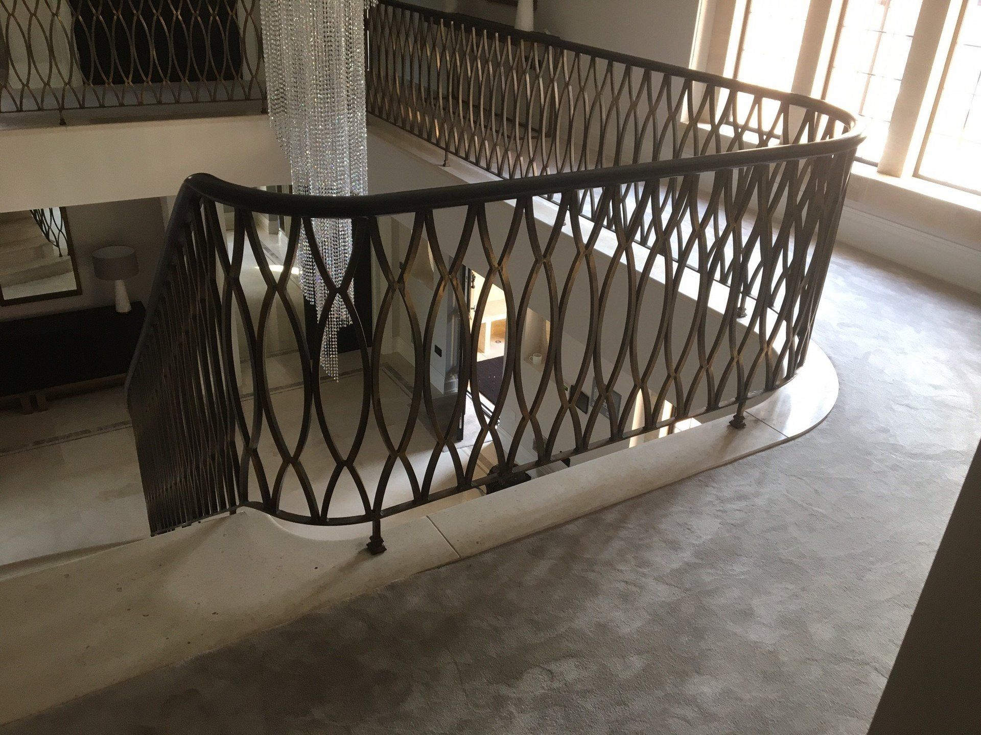 A staircase with a wrought iron railing and a carpeted floor