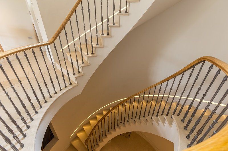 A spiral staircase with a metal railing and wooden steps.
