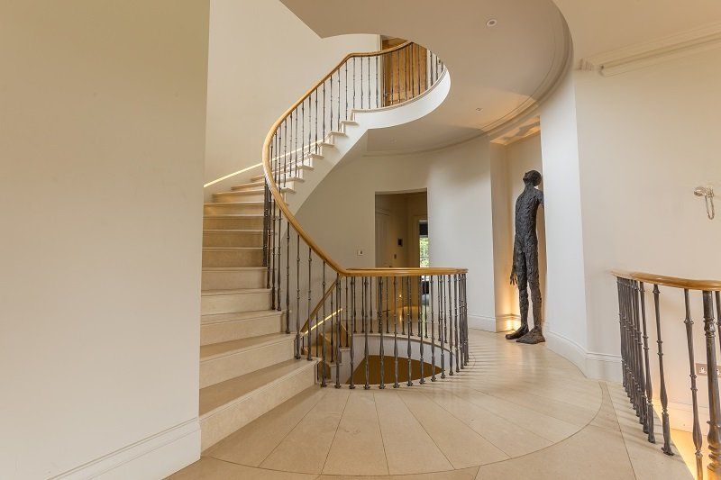 There is a statue of a man standing next to a spiral staircase.