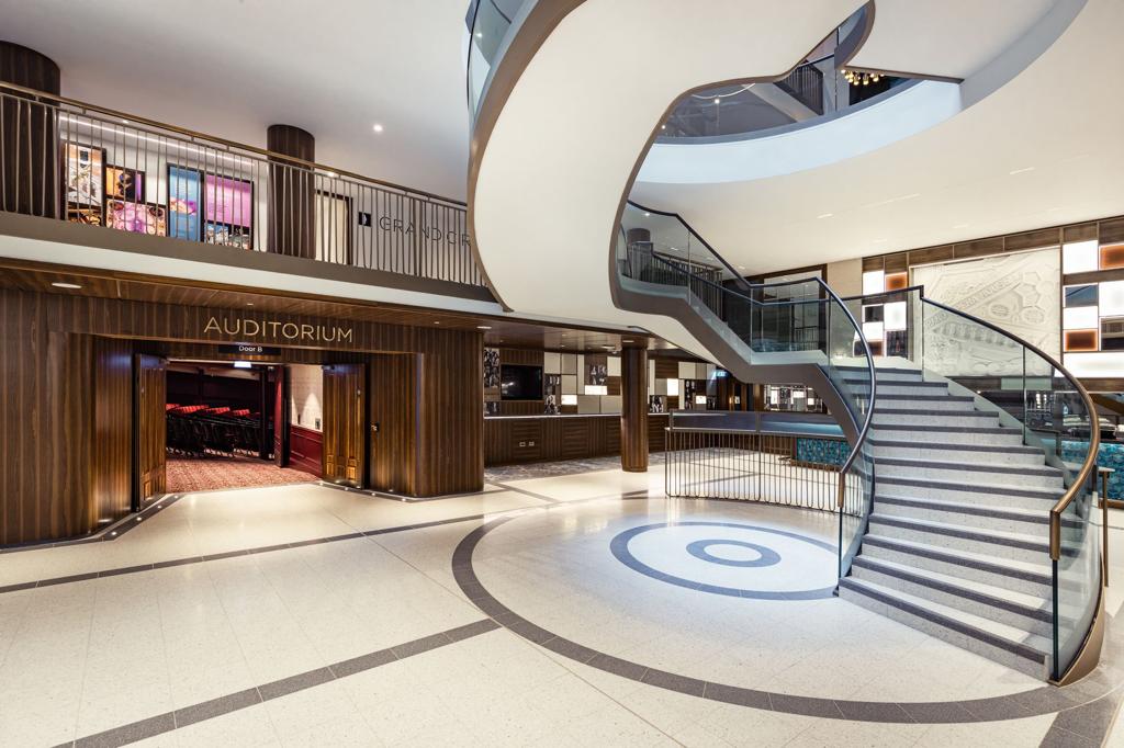 A large lobby with a spiral staircase and a balcony.