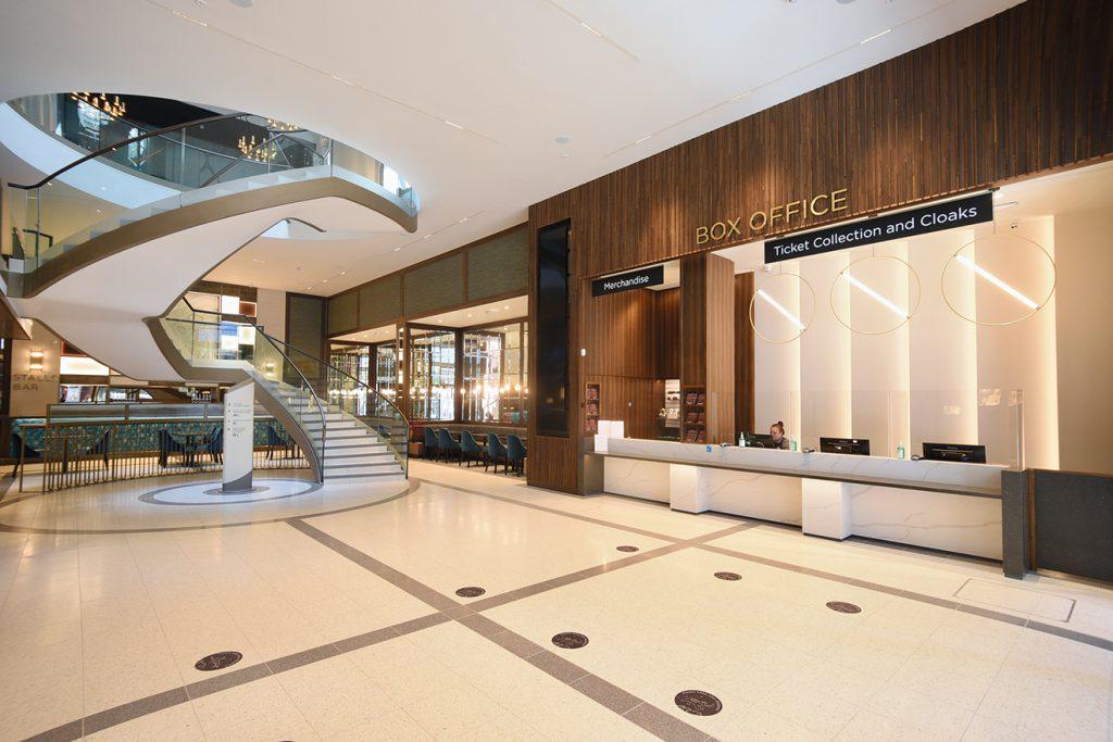 A large lobby with a staircase and a reception desk.
