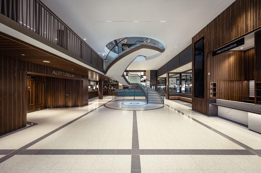 There is a staircase in the middle of the lobby of a building.