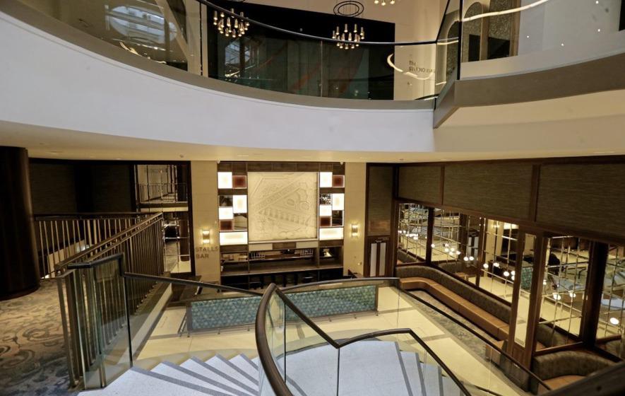 A hotel lobby with stairs leading up to the second floor