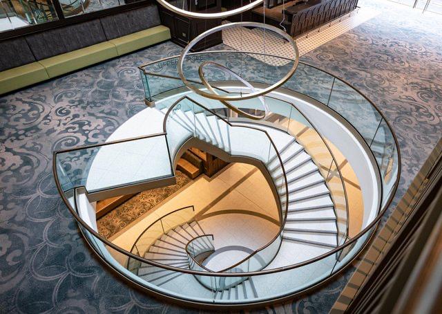 A spiral staircase with a glass railing in a building.