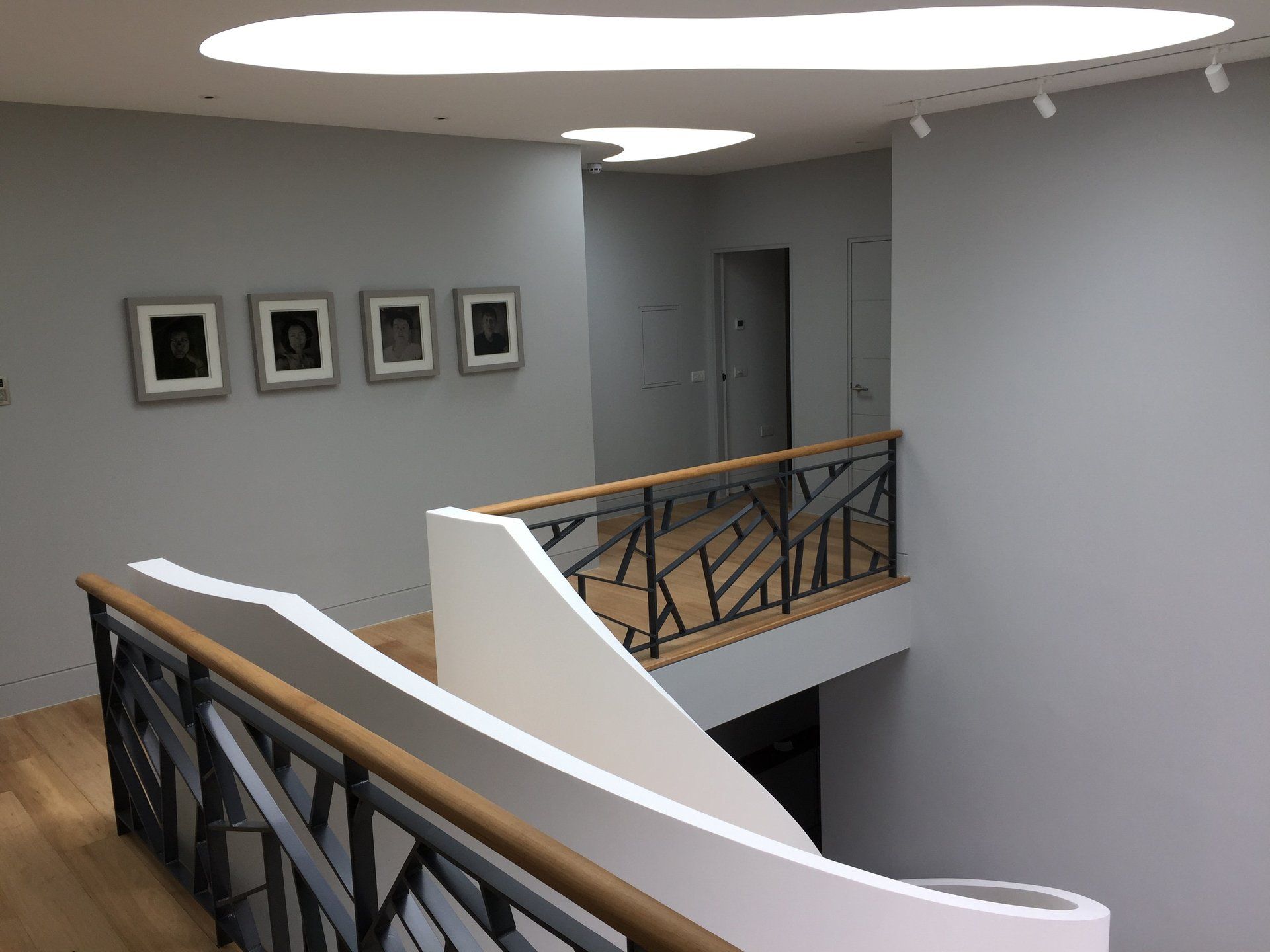 A staircase with a railing and pictures on the wall