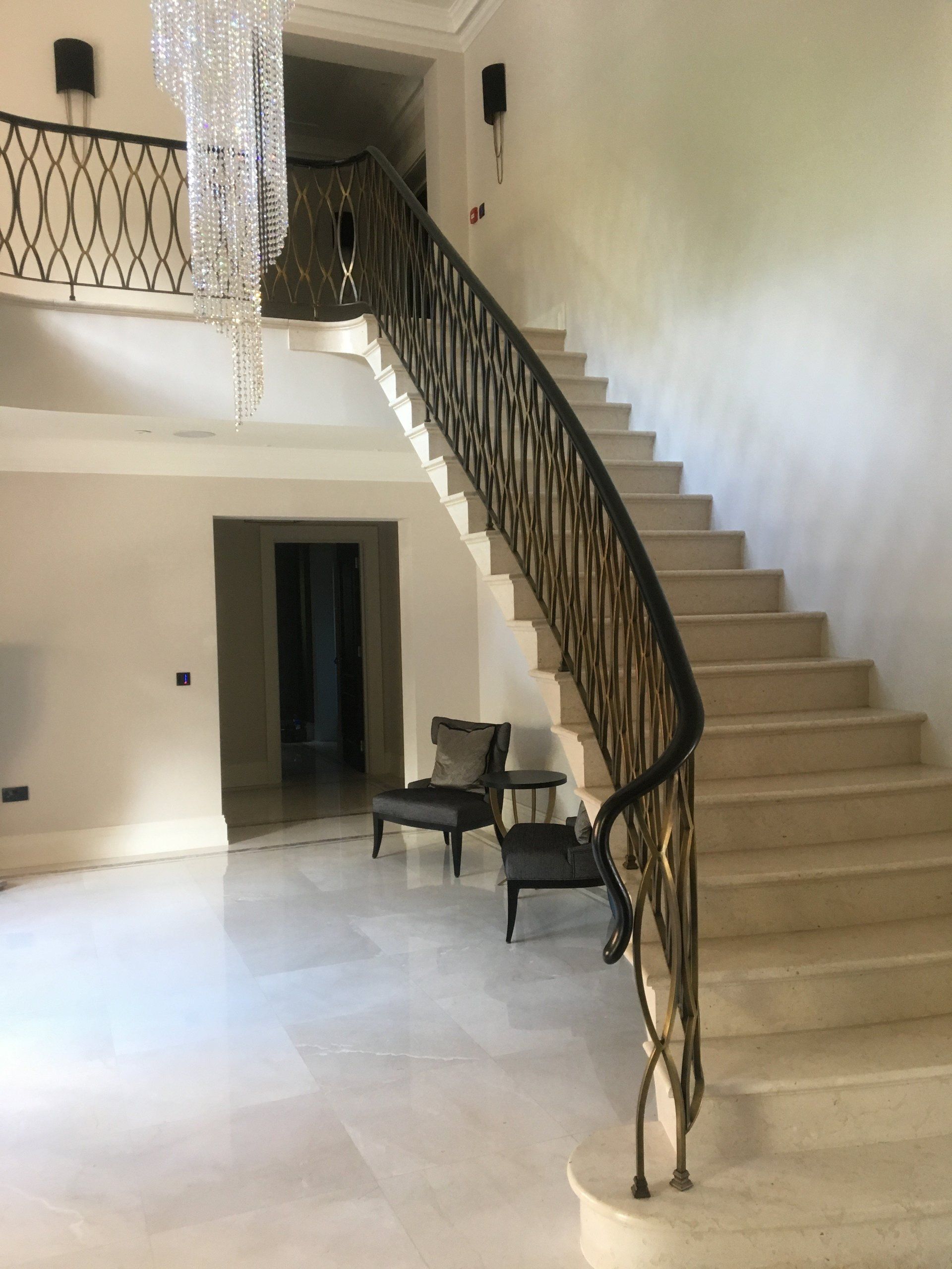 A staircase with a wrought iron railing in a large room