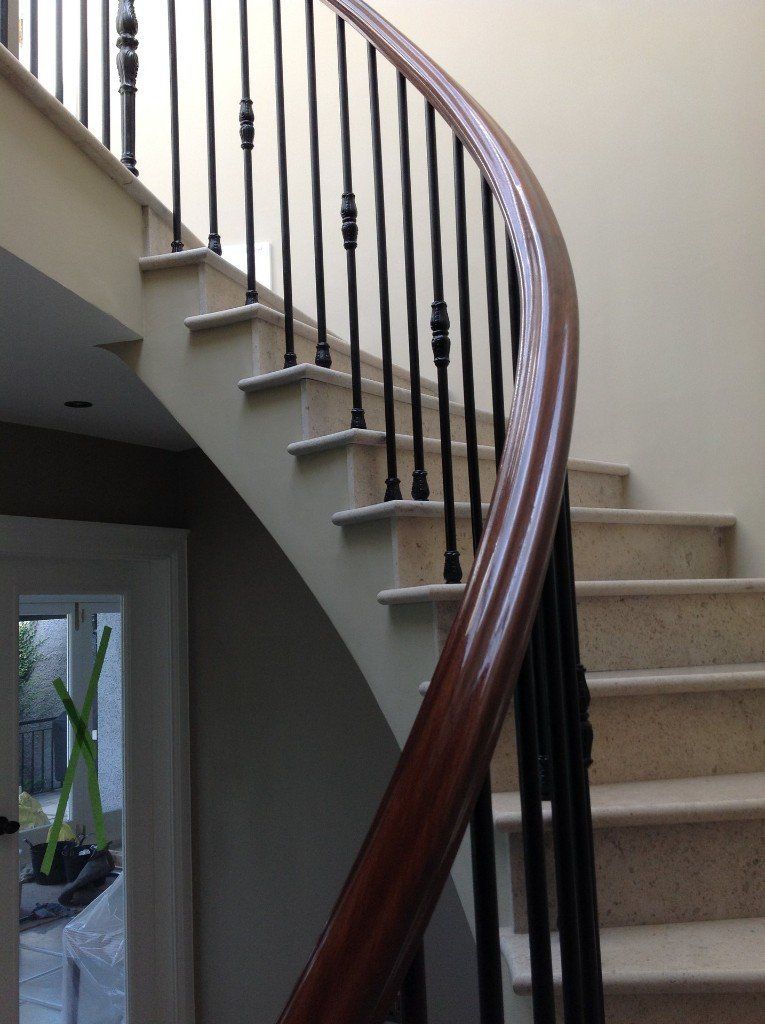 A staircase with a wooden railing and a metal railing