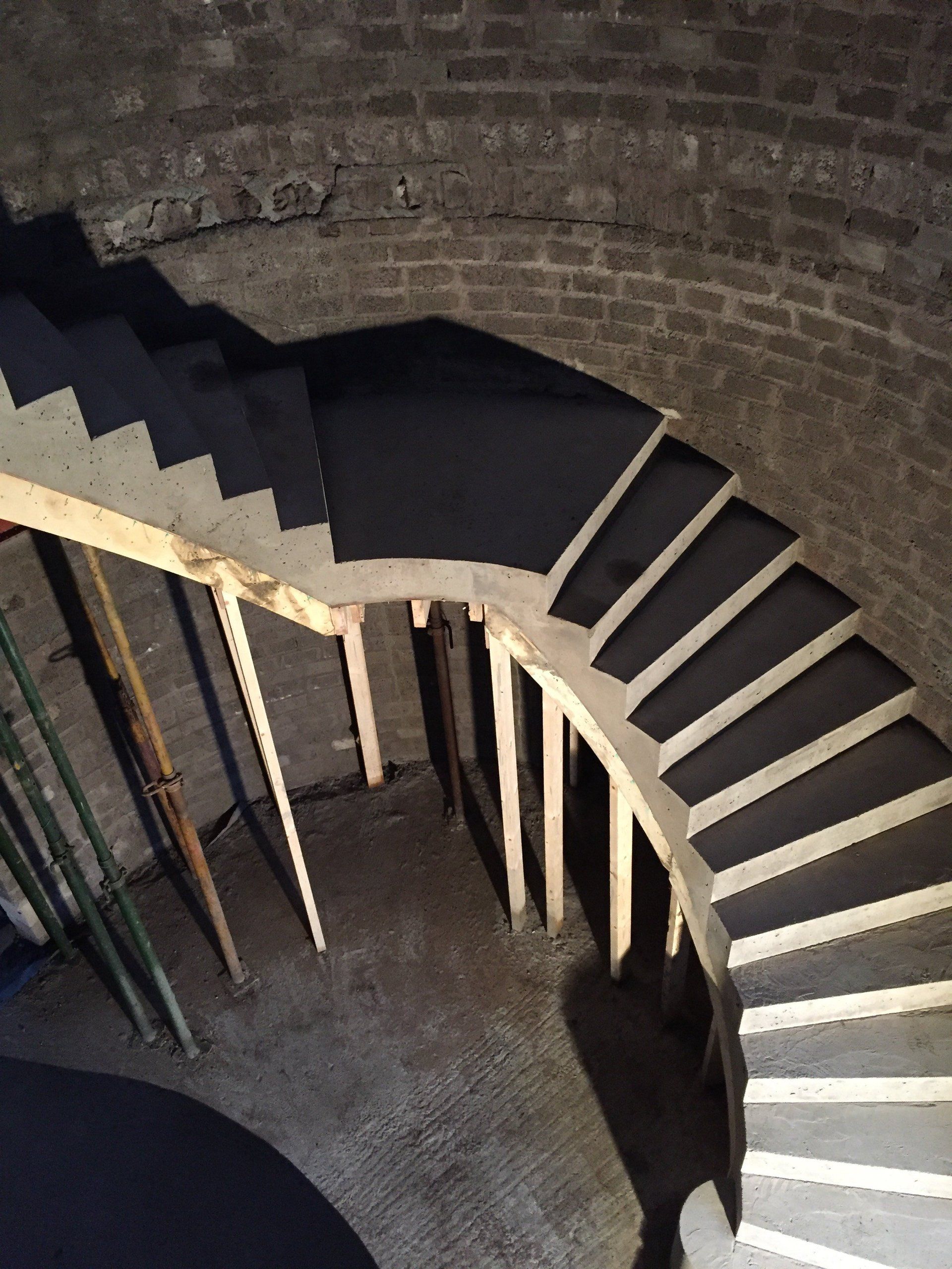 A spiral staircase is being built in a brick building
