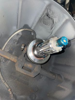 Inside a vehicle's transmission housing: a clutch release bearing assembly with a greased shaft and lever arm.