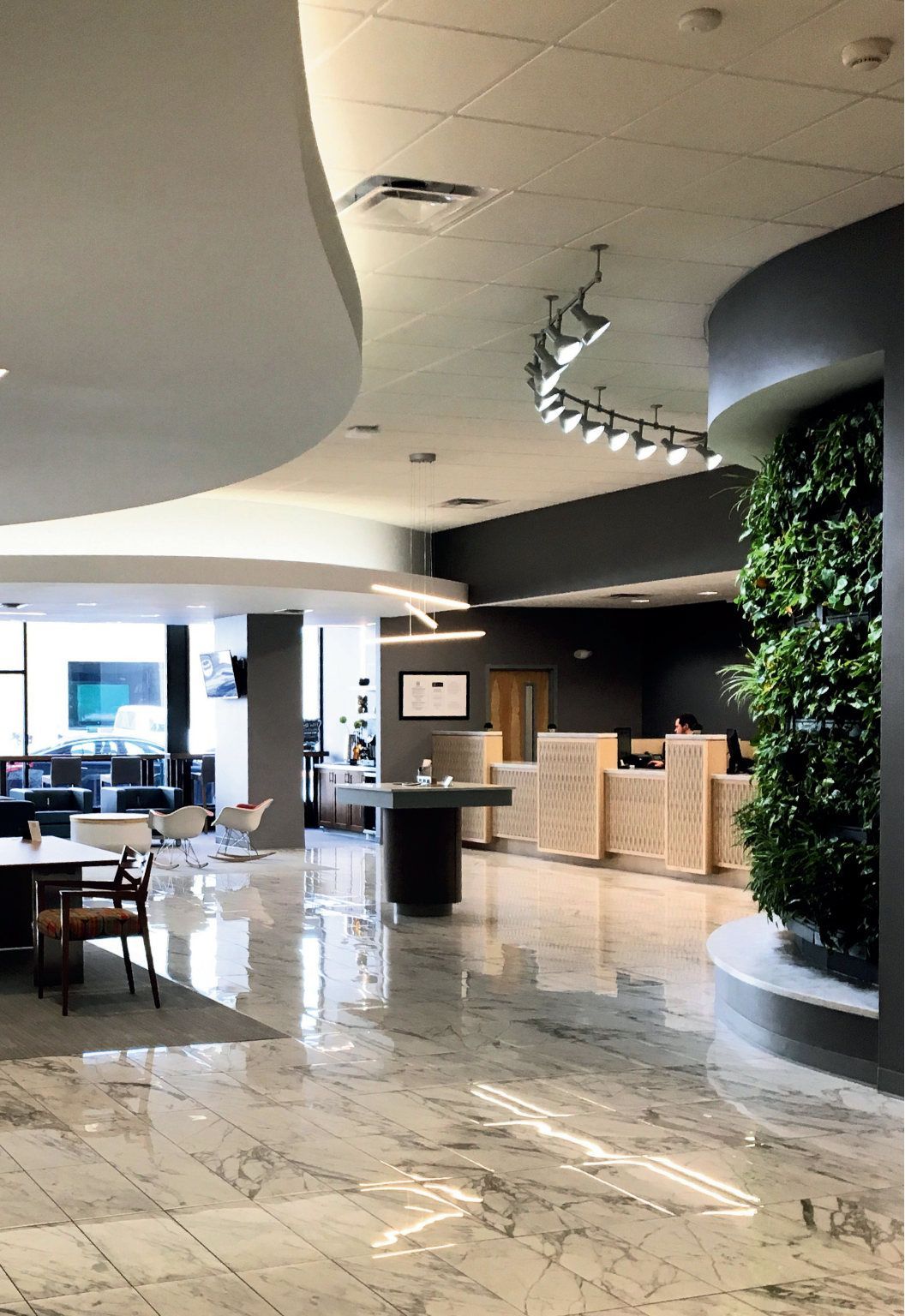 A lobby with tables and chairs and a green wall