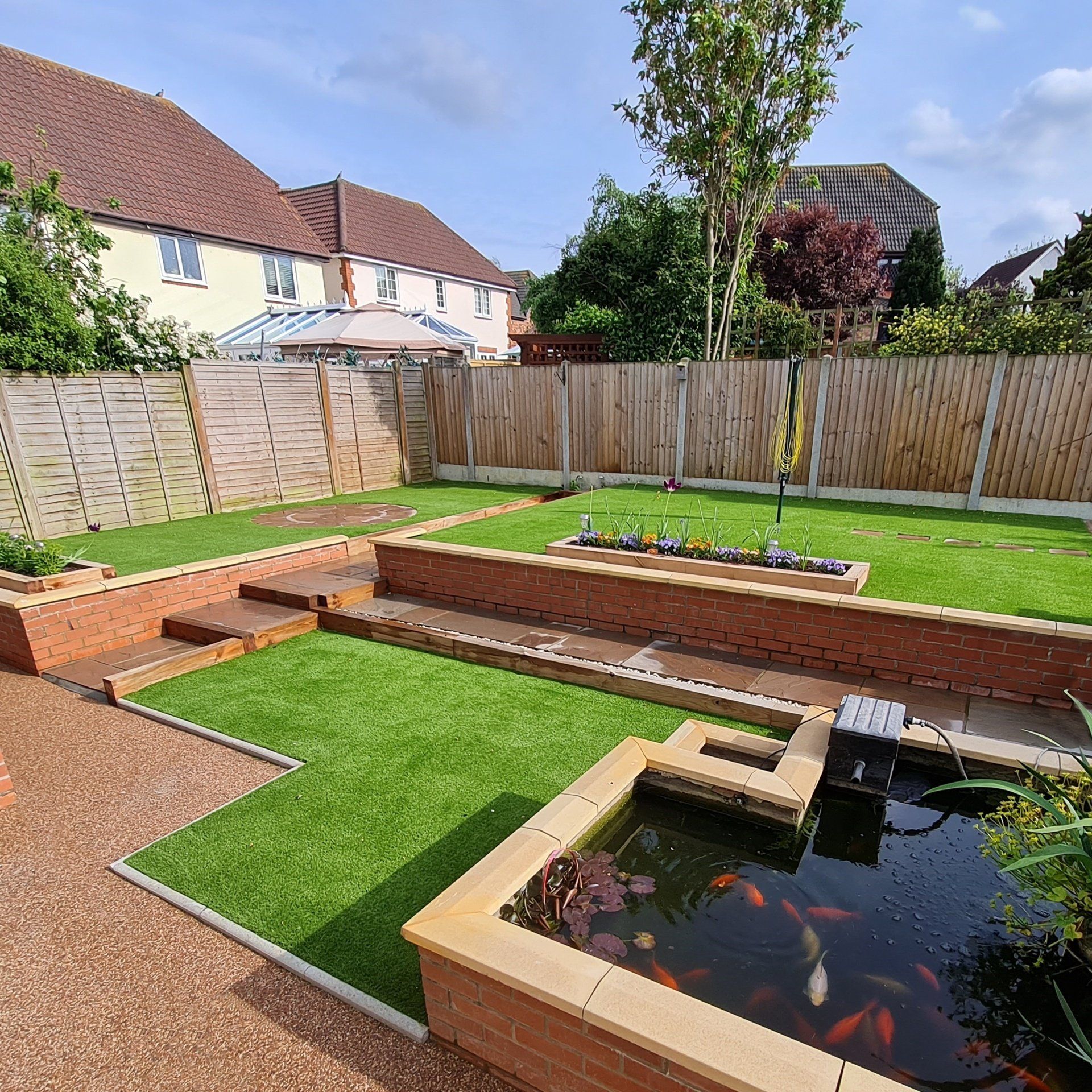 Landscaped gardens with artificial grass installed