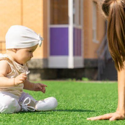 A baby enjoying an artificial grass lawns in a Felixstowe garden