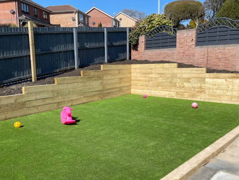 Wooden borders and artificial lawns showing landscaping services