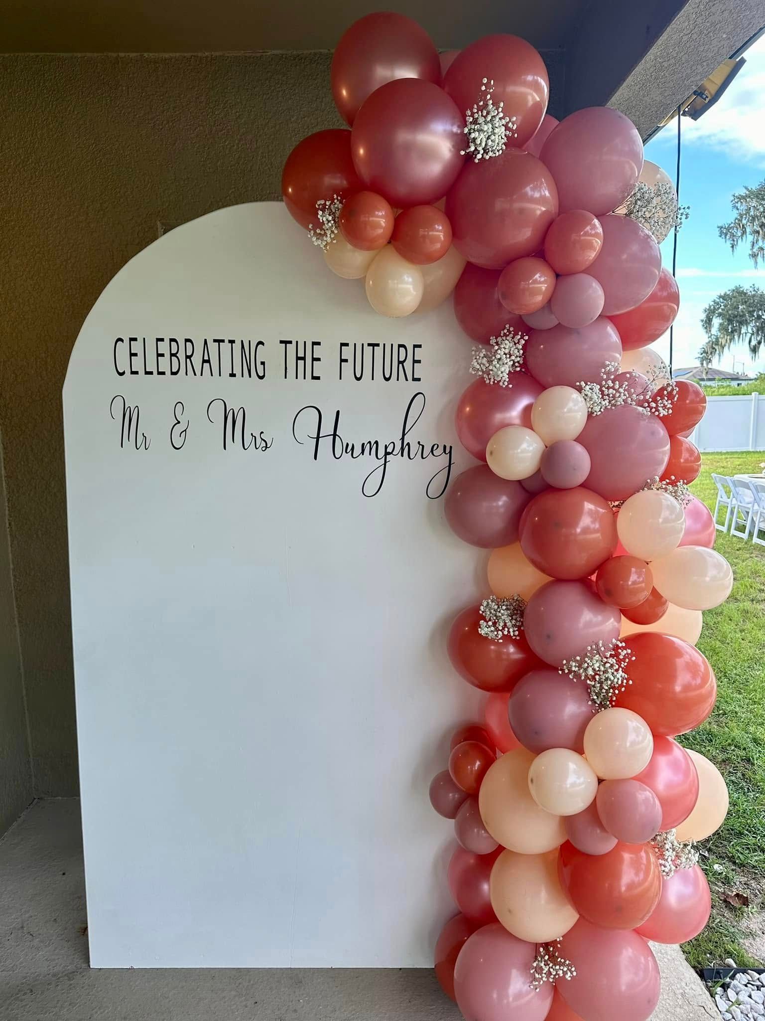 A bunch of balloons are sitting on top of a white wall.
