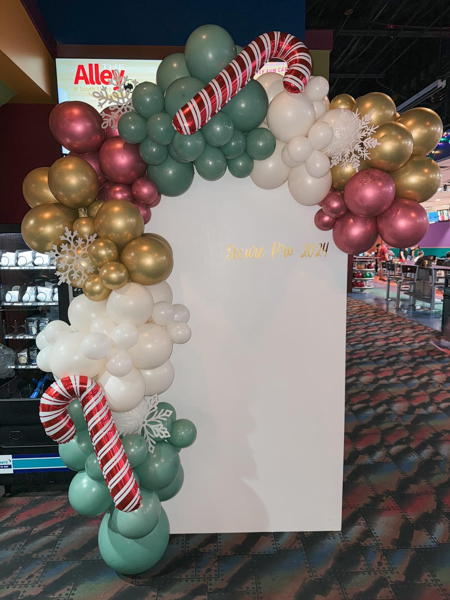 A christmas balloon arch with candy canes and snowflakes.