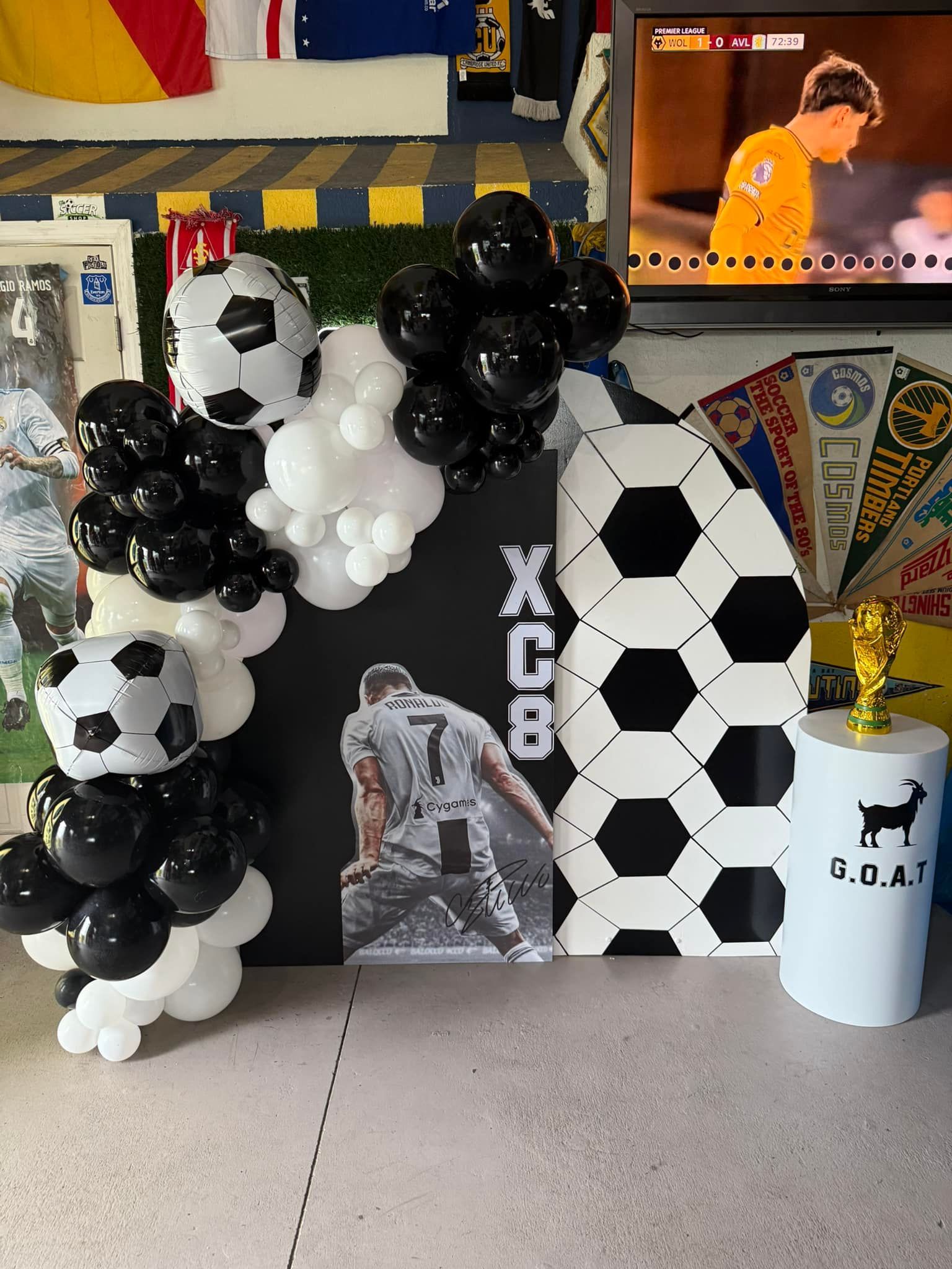A room decorated with soccer balls and balloons and a picture of a soccer player.