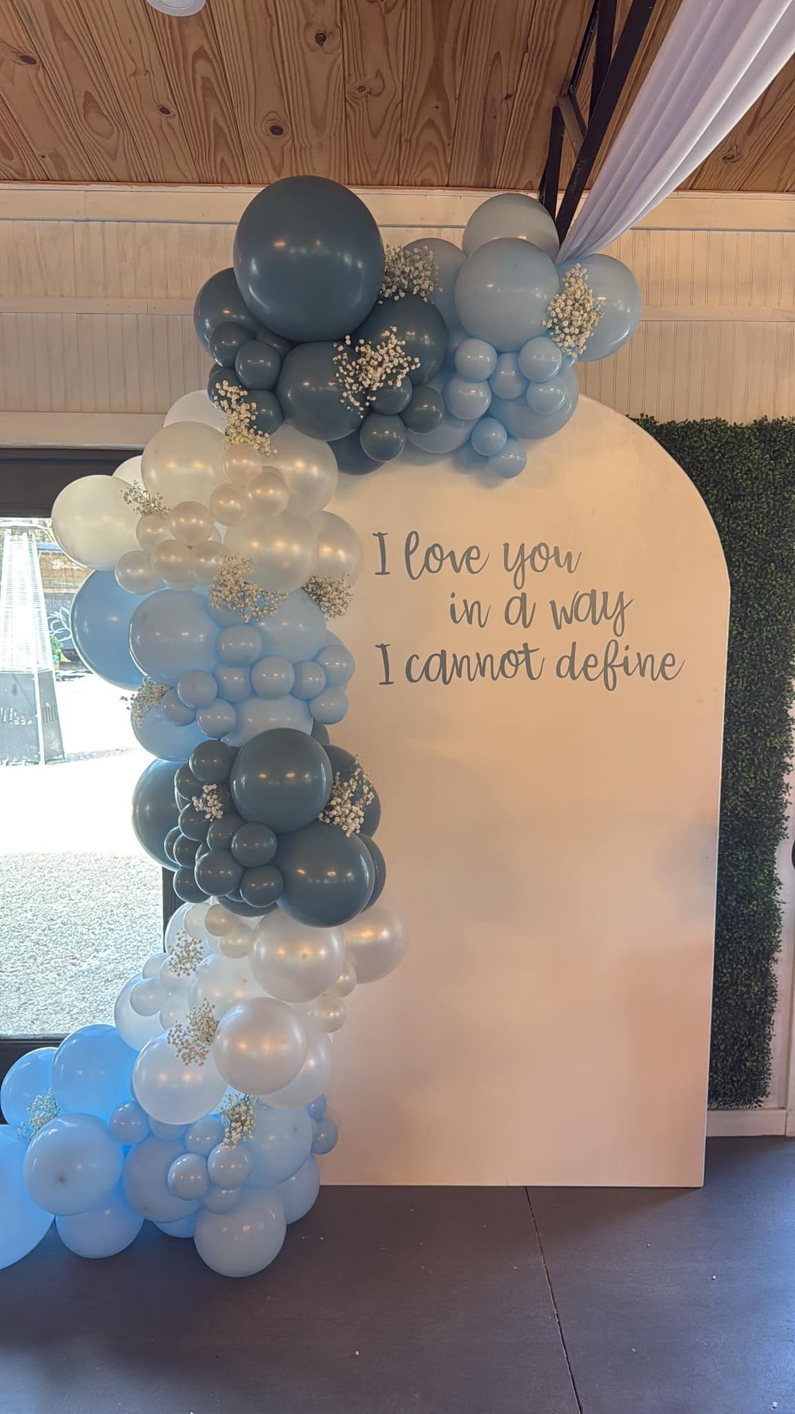 There is a sign that says `` i love you '' surrounded by balloons.