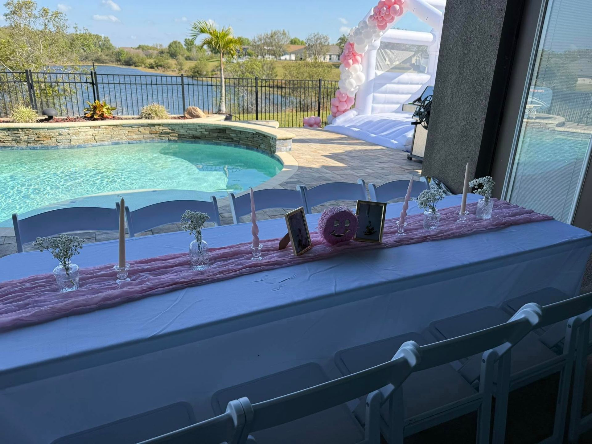 A table set up for a party with a pool in the background.