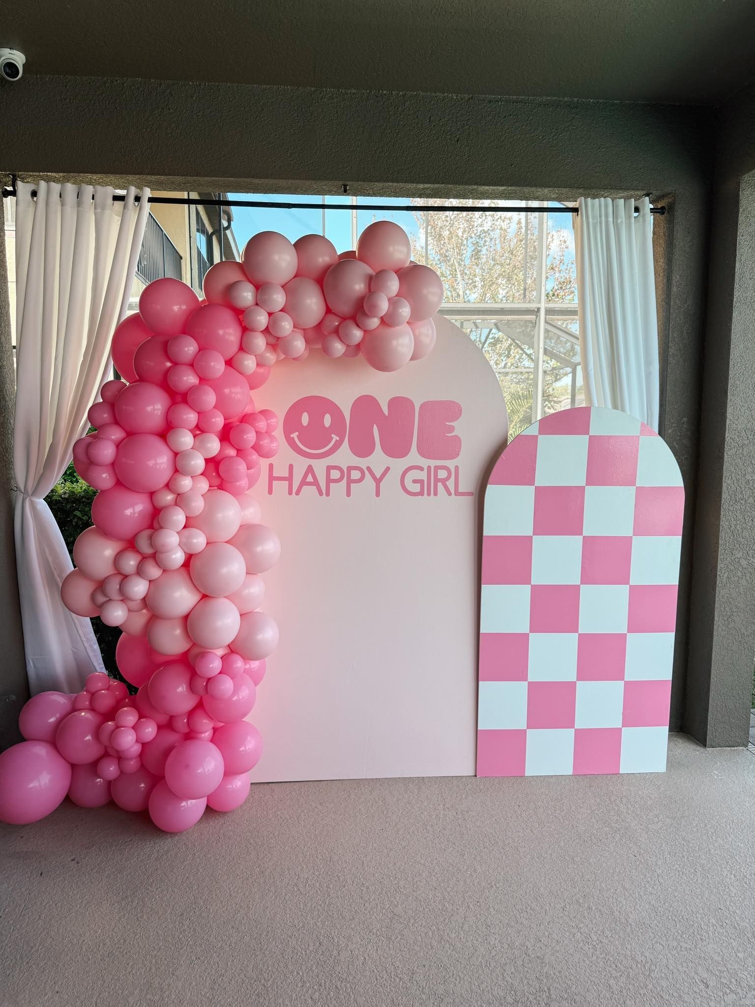 A wall with pink balloons and a sign that says `` one happy girl ''.
