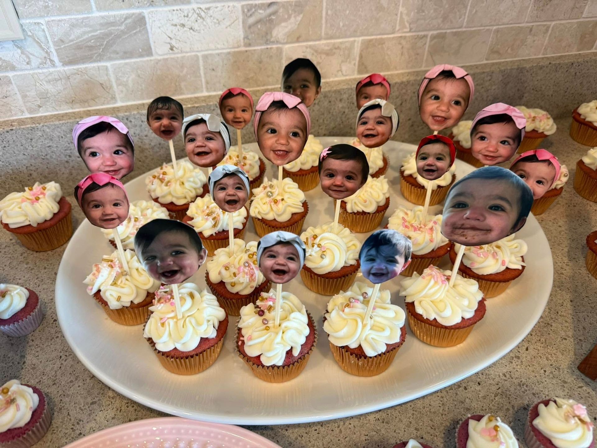 A plate of cupcakes with children 's faces on them