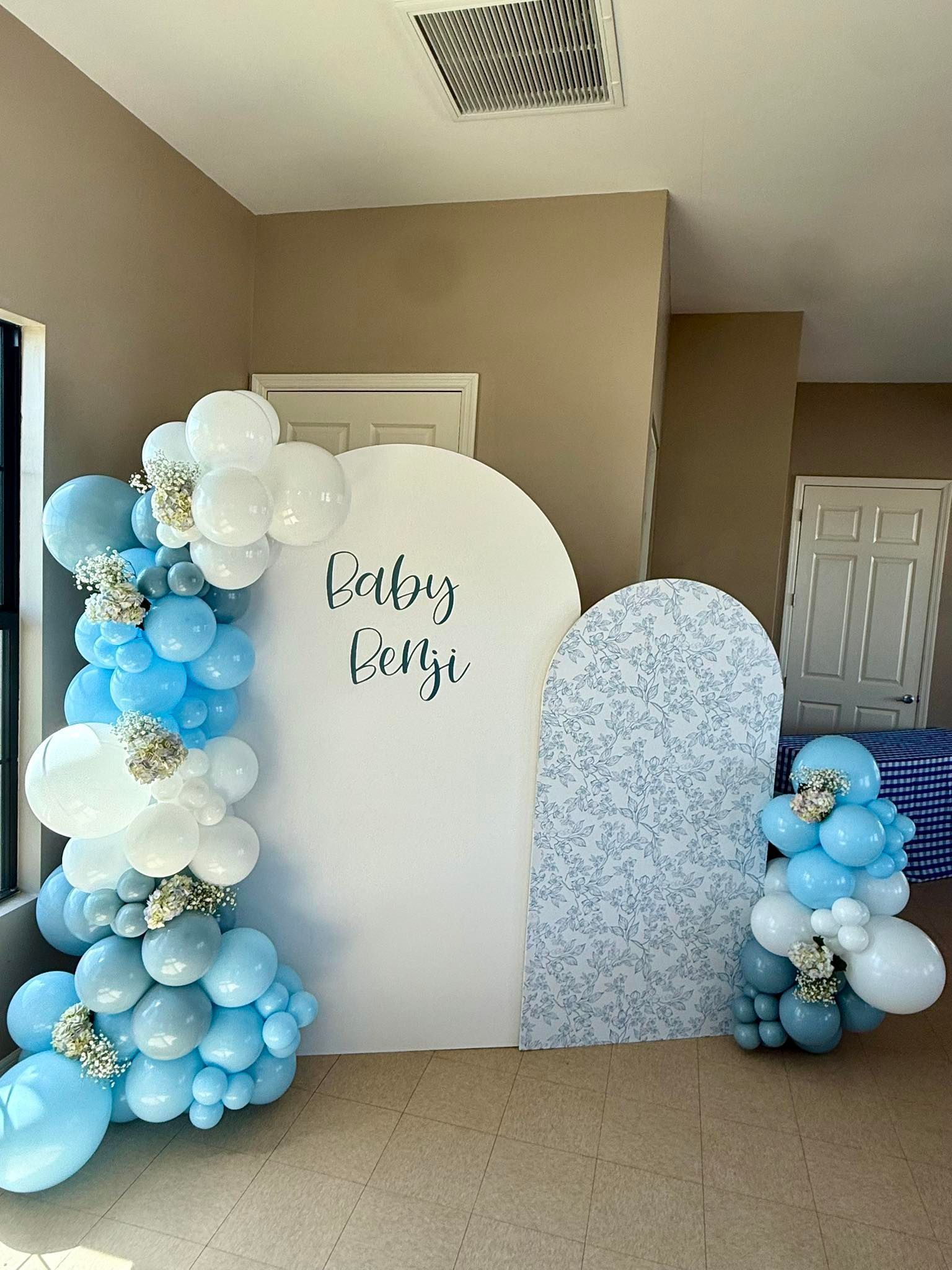 A room filled with blue and white balloons and a white wall.