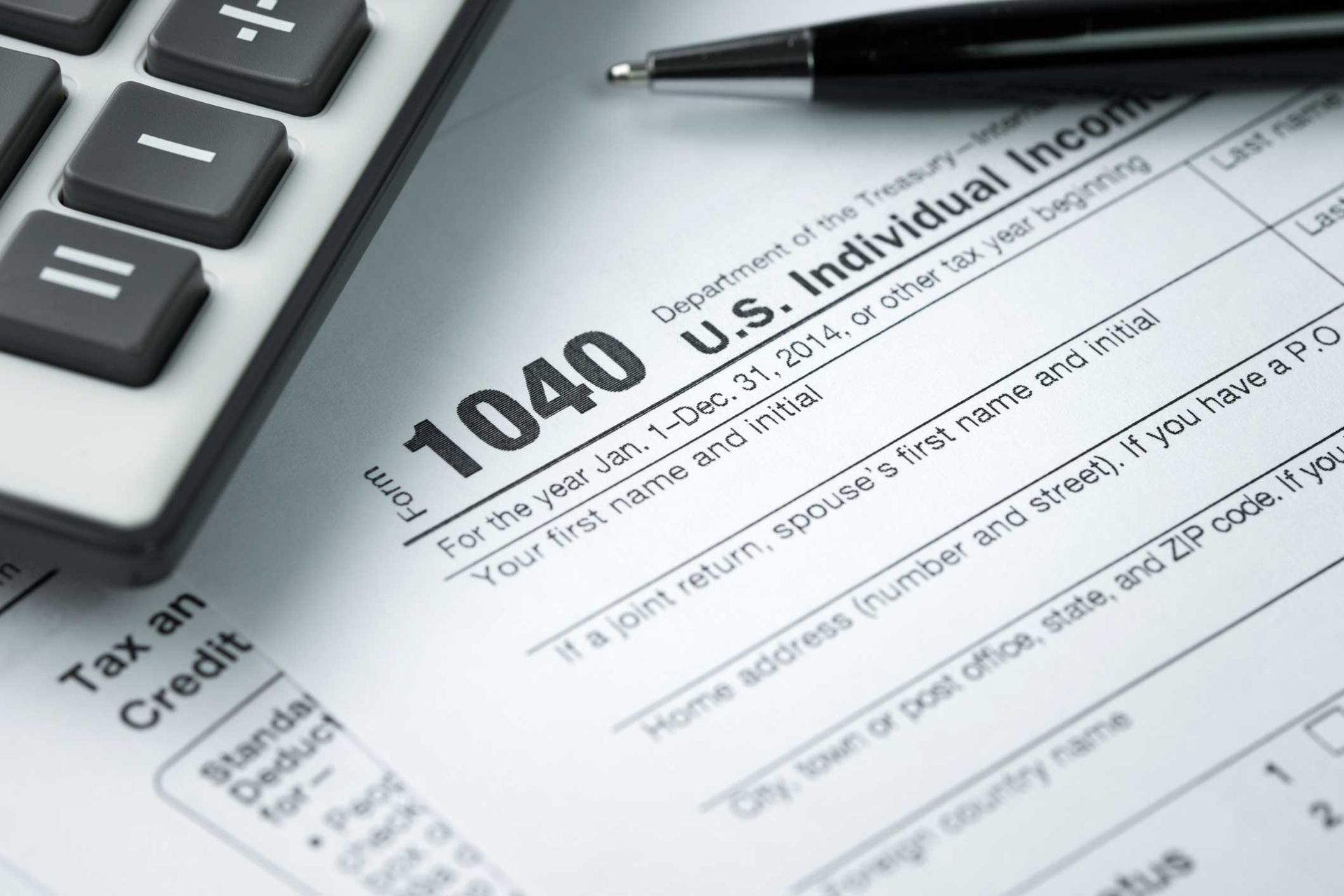 A pen is sitting on top of a 1040 tax form