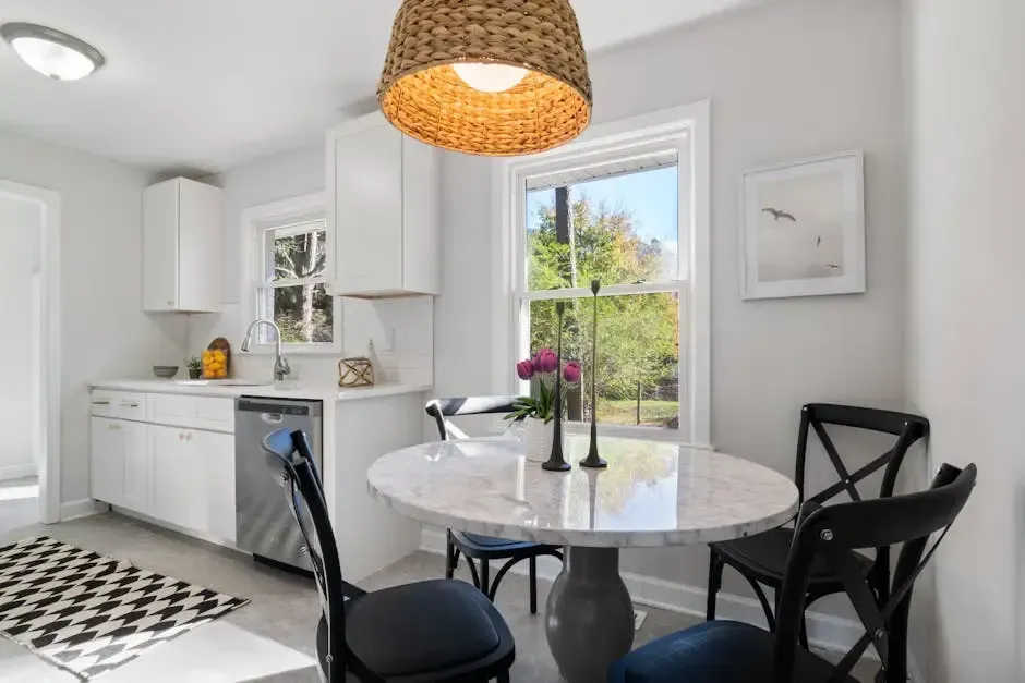 A kitchen with a table and chairs and a window