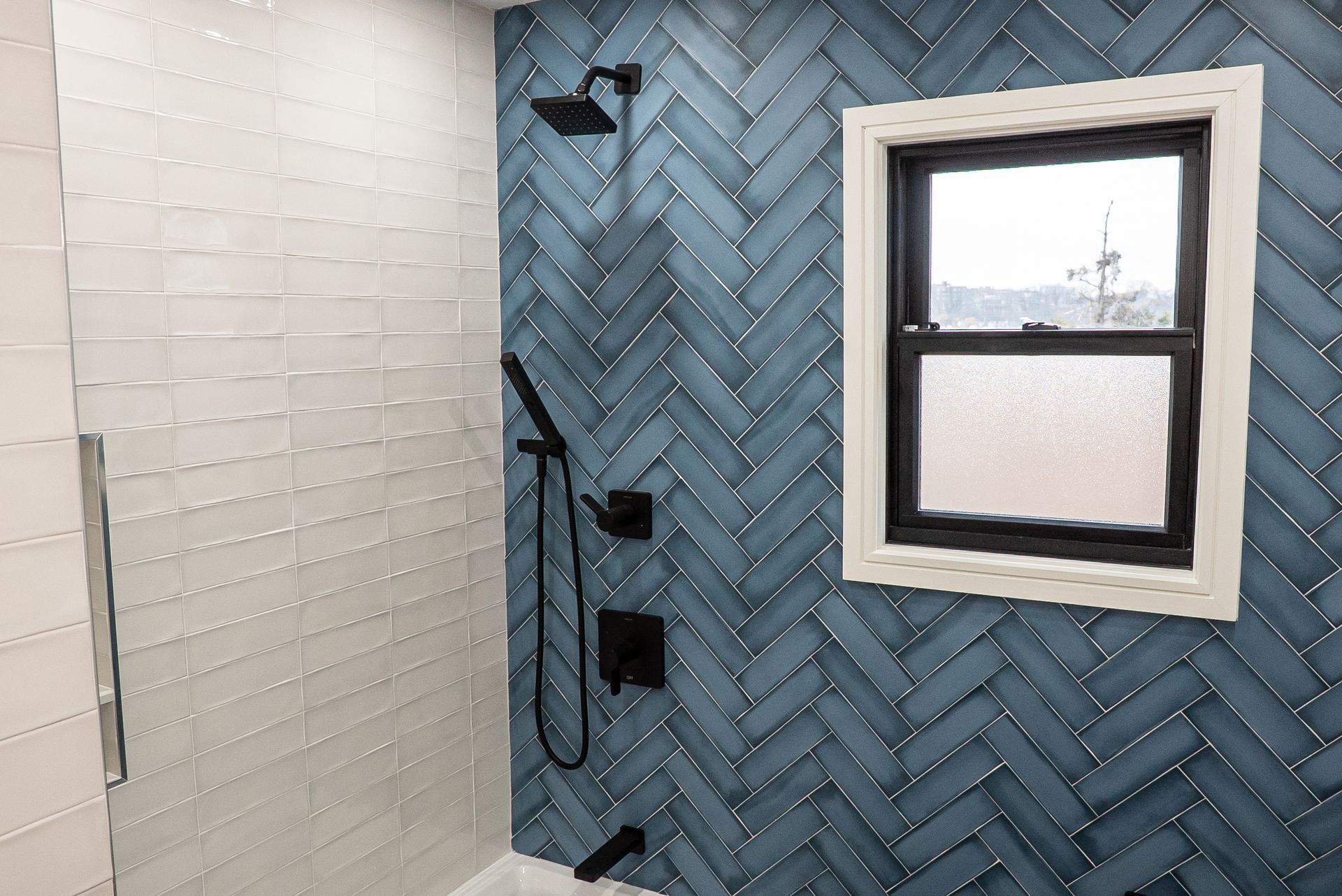 A bathroom with blue and white tiles and a window