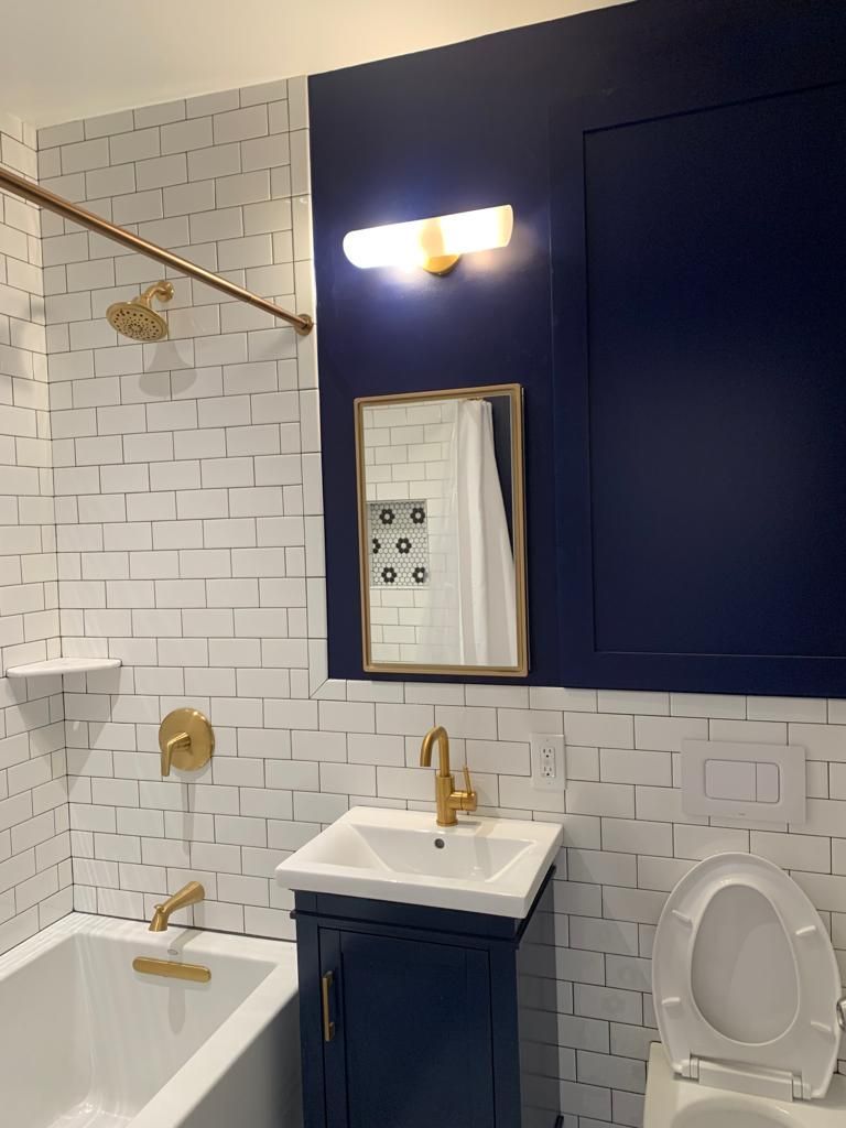 A bathroom with a bathtub, sink, toilet and mirror