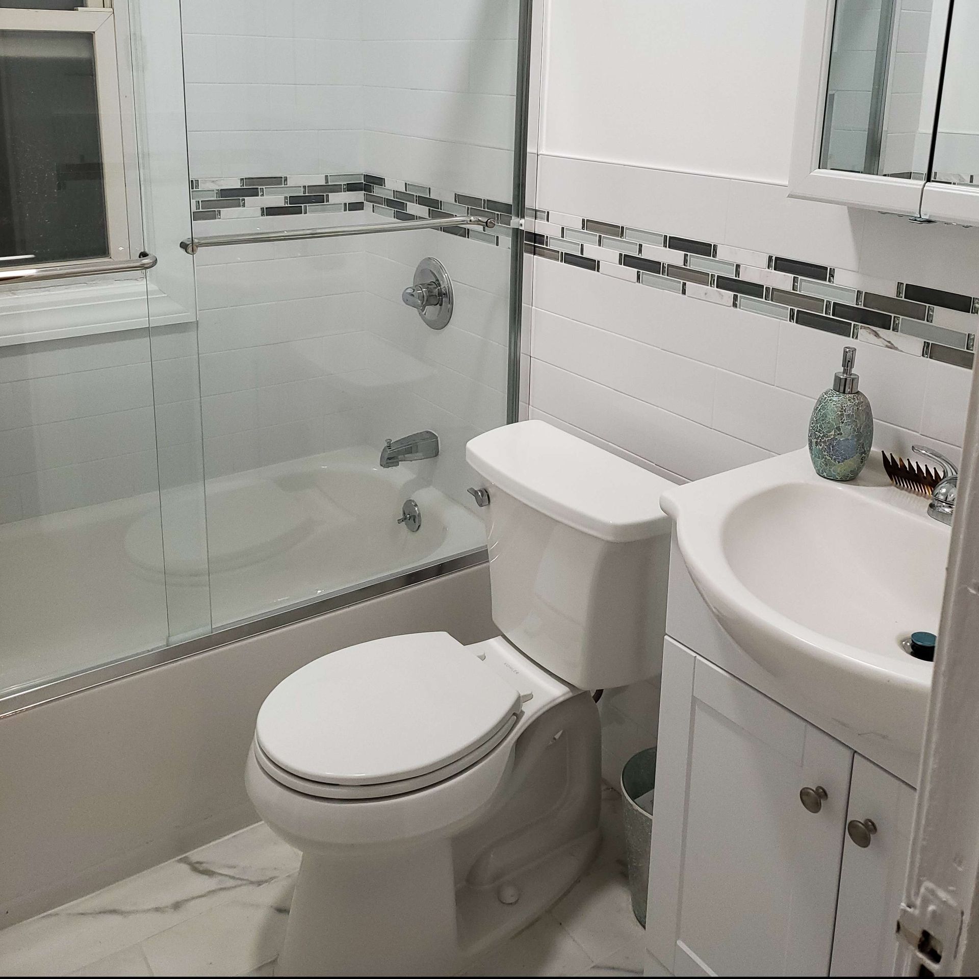 A bathroom with a toilet a sink and a bathtub