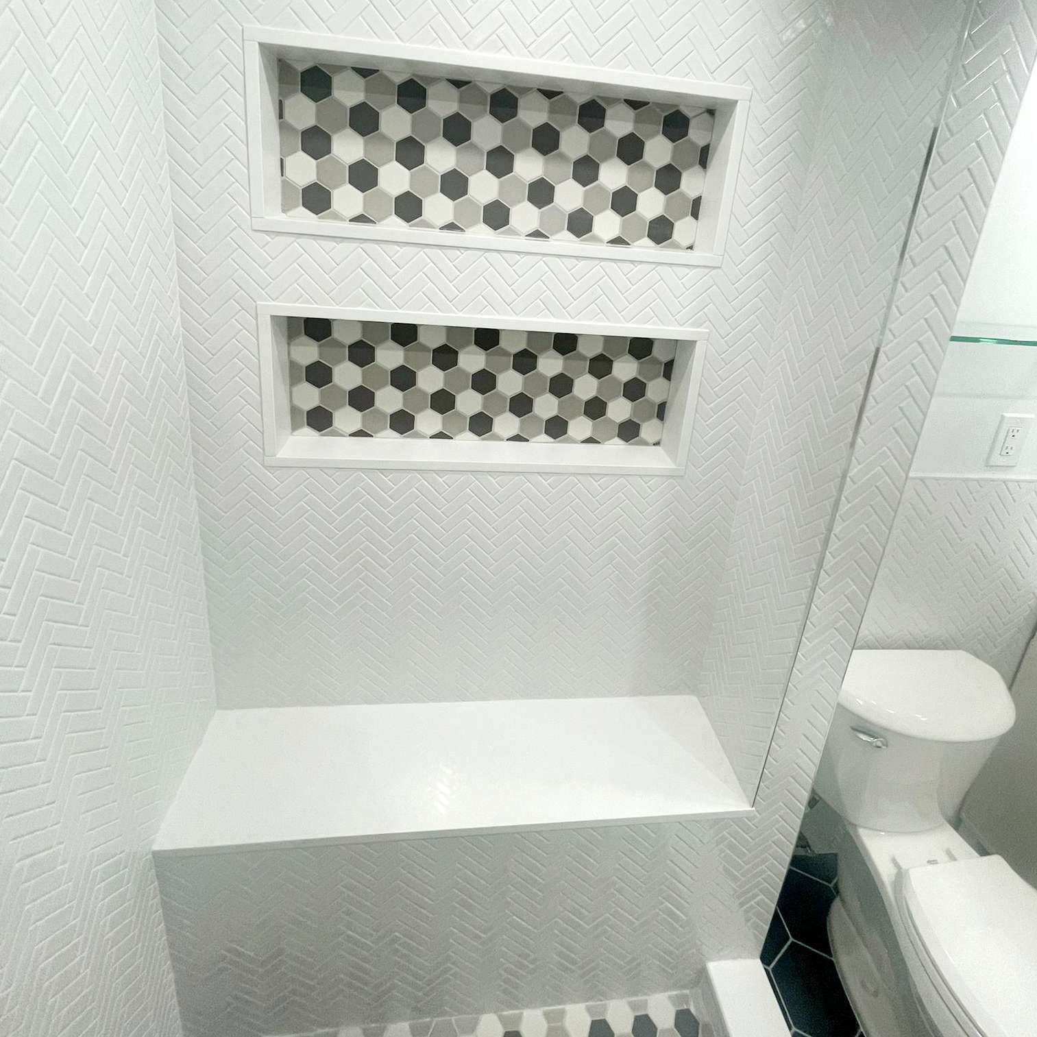 A bathroom with three shelves and a toilet