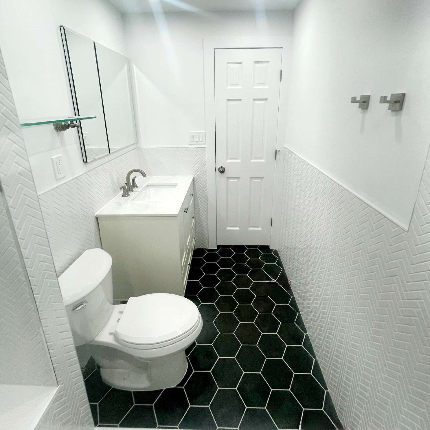 A bathroom with a toilet a sink and a mirror