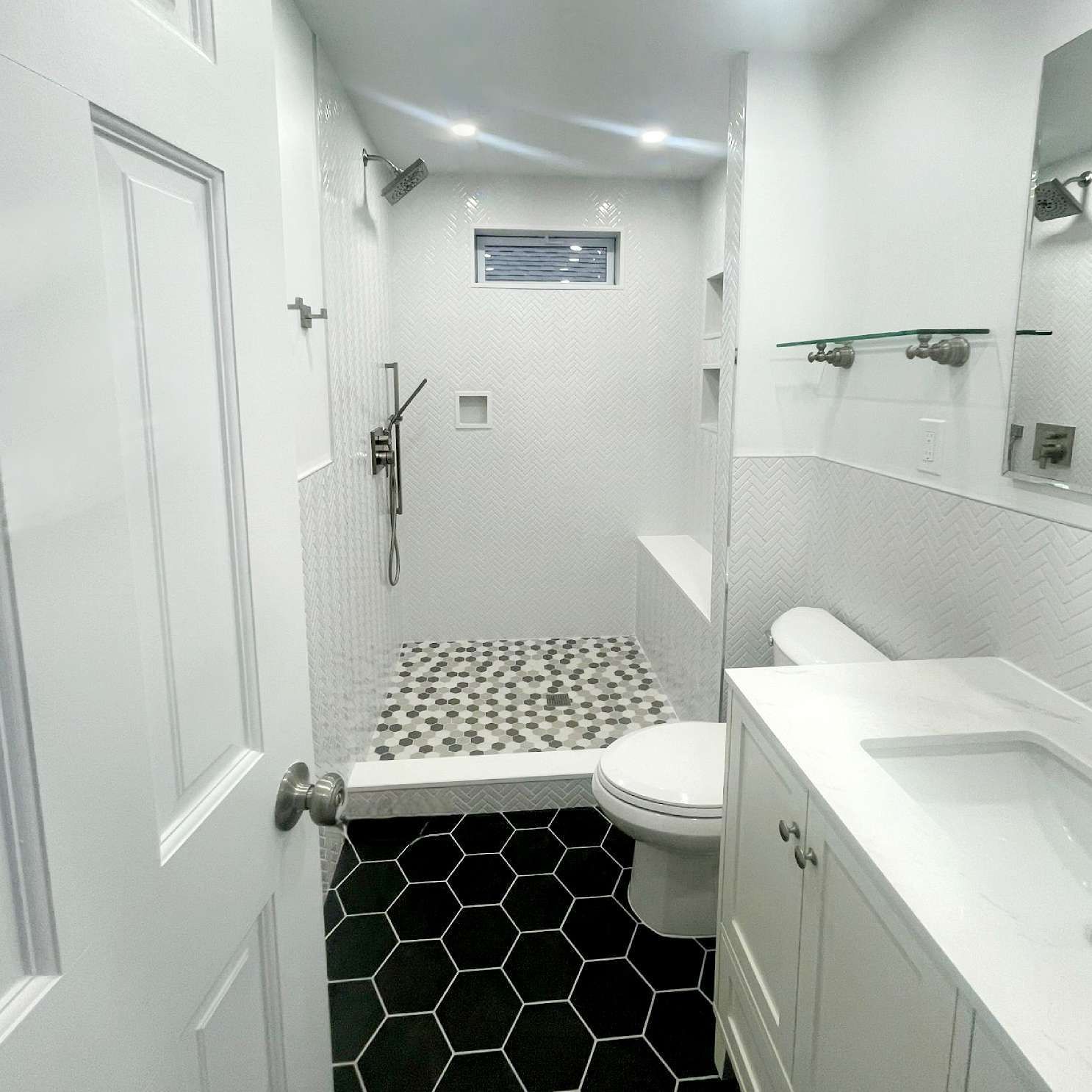 A bathroom with a toilet a sink and a shower