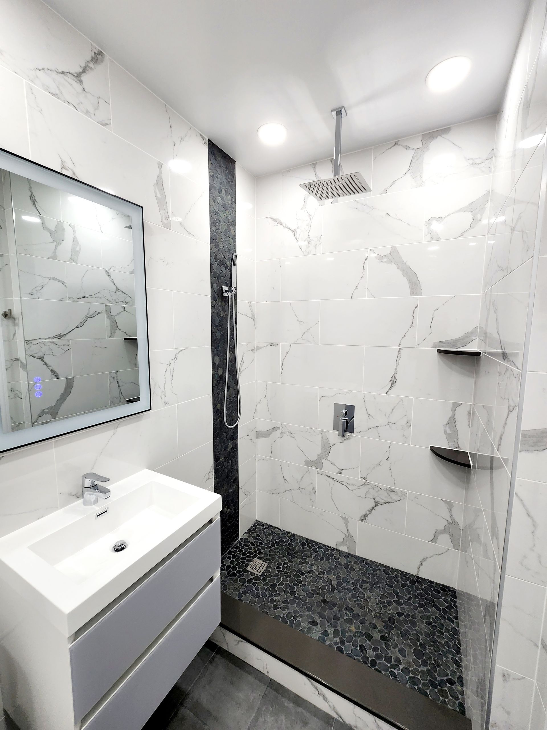 A bathroom with a sink, mirror and shower