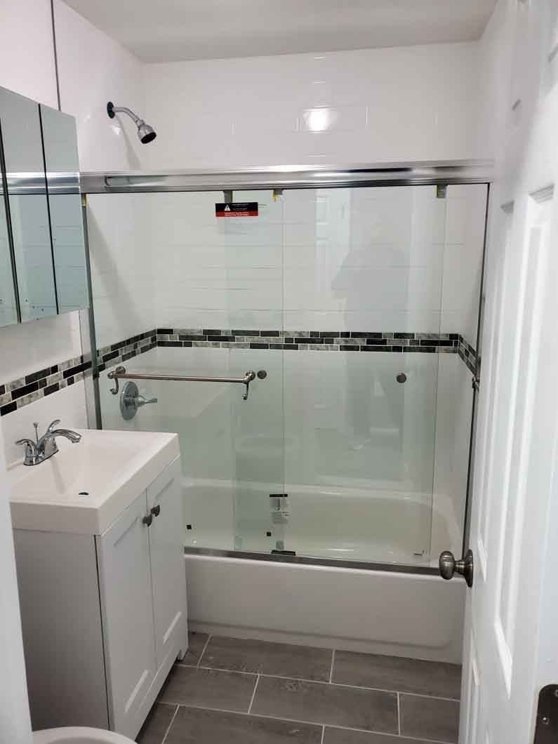 A bathroom with a sink, tub, shower and mirror