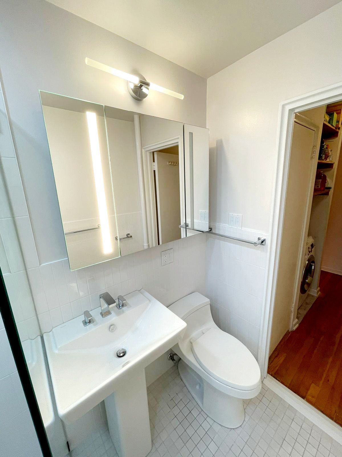 A bathroom with a toilet, sink and mirror