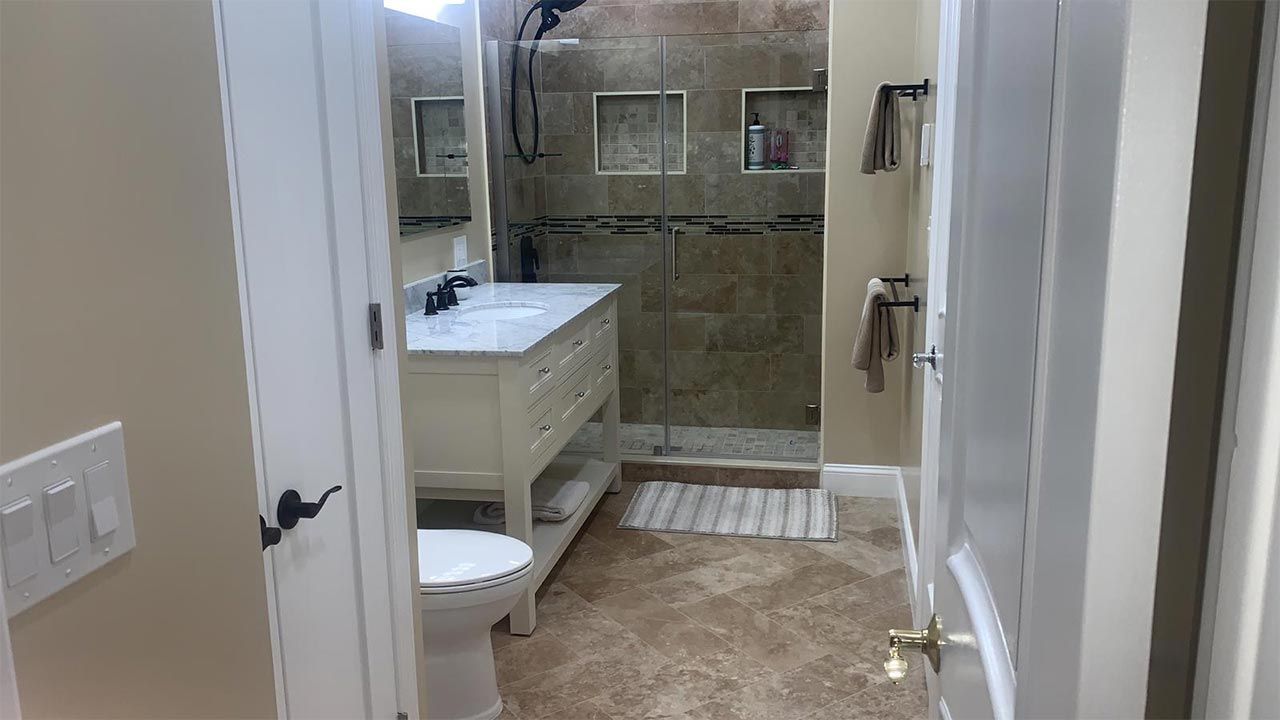 A bathroom with a toilet, sink, and walk in shower