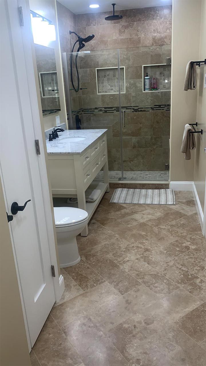 A bathroom with a toilet, sink, and walk in shower
