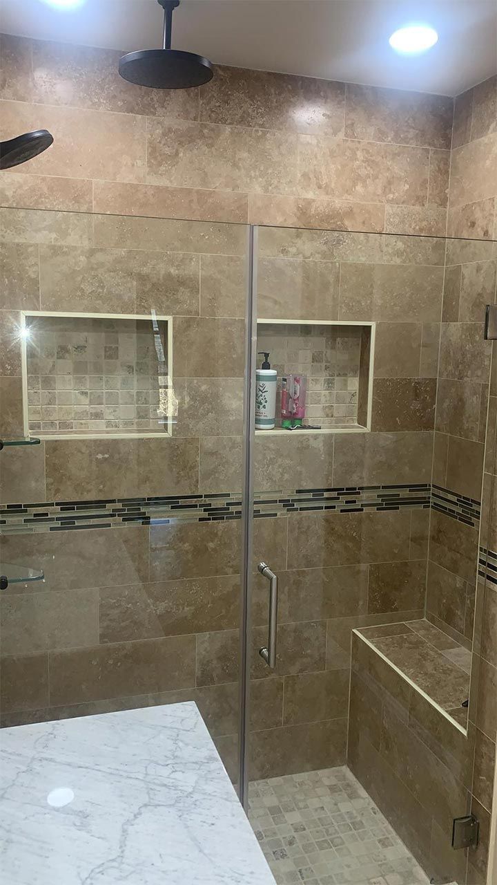 A bathroom with a walk in shower and a ceiling fan