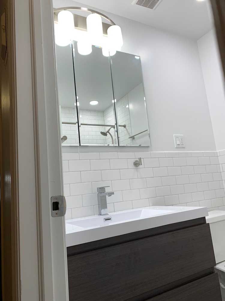 A bathroom with a sink, mirror and shower