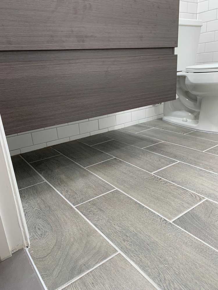 A bathroom with a toilet, sink, and tile floor