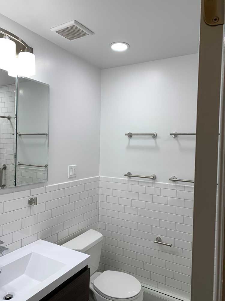 A bathroom with a toilet, sink and mirror