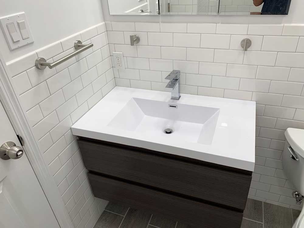 A bathroom with a sink, toilet and mirror