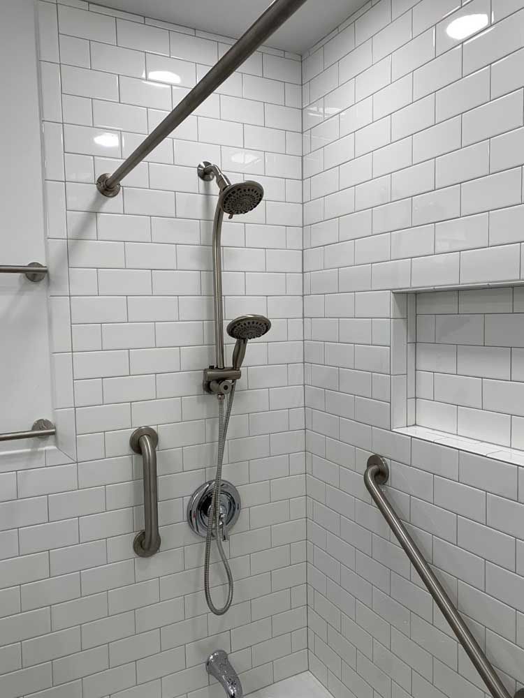 A bathroom with white brick walls and a shower head