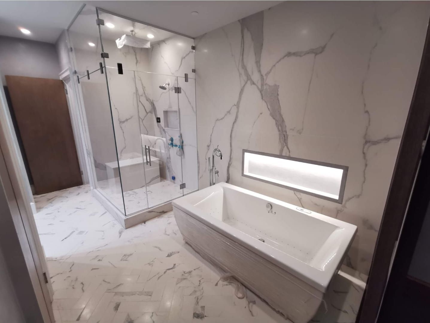 A bathroom with a bathtub and a walk in shower