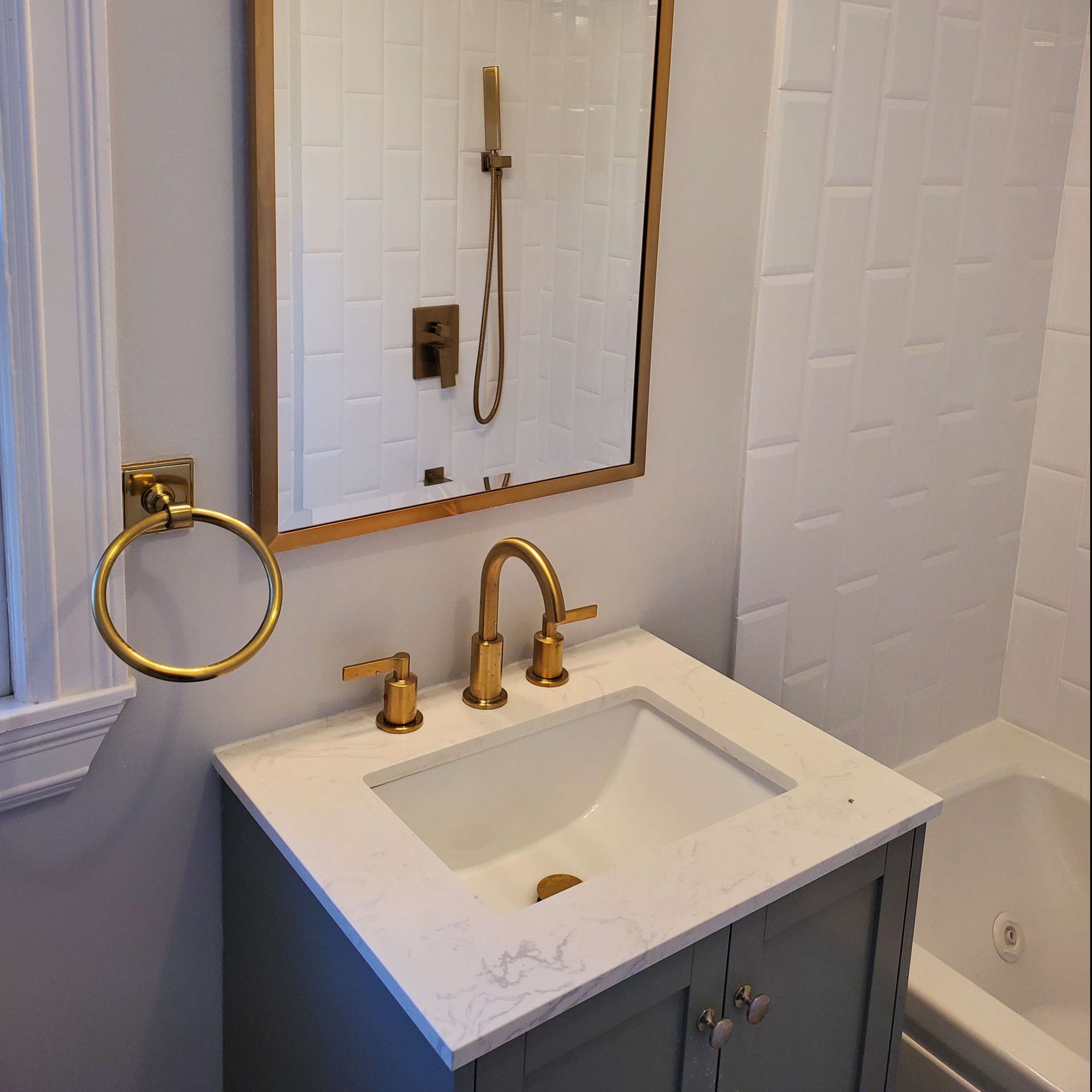 A bathroom with a sink, mirror and tub