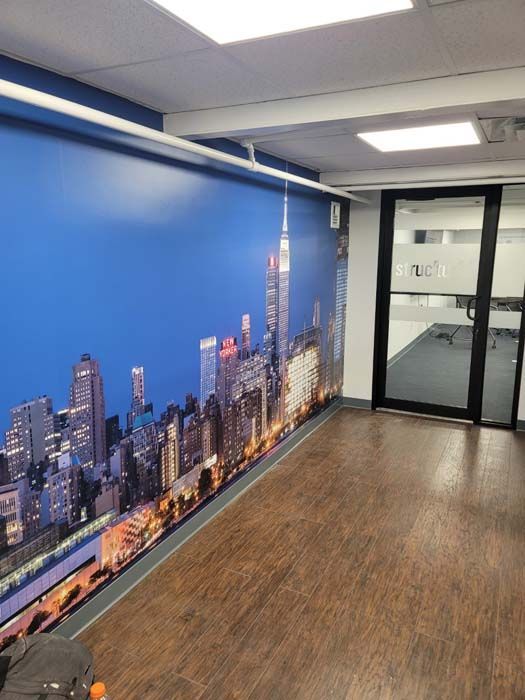 A room with a large picture of a city skyline on the wall