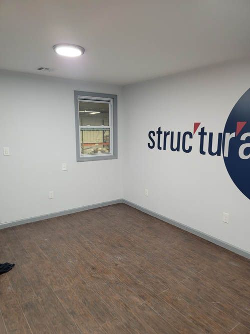 An empty room with a sign on the wall that says structure